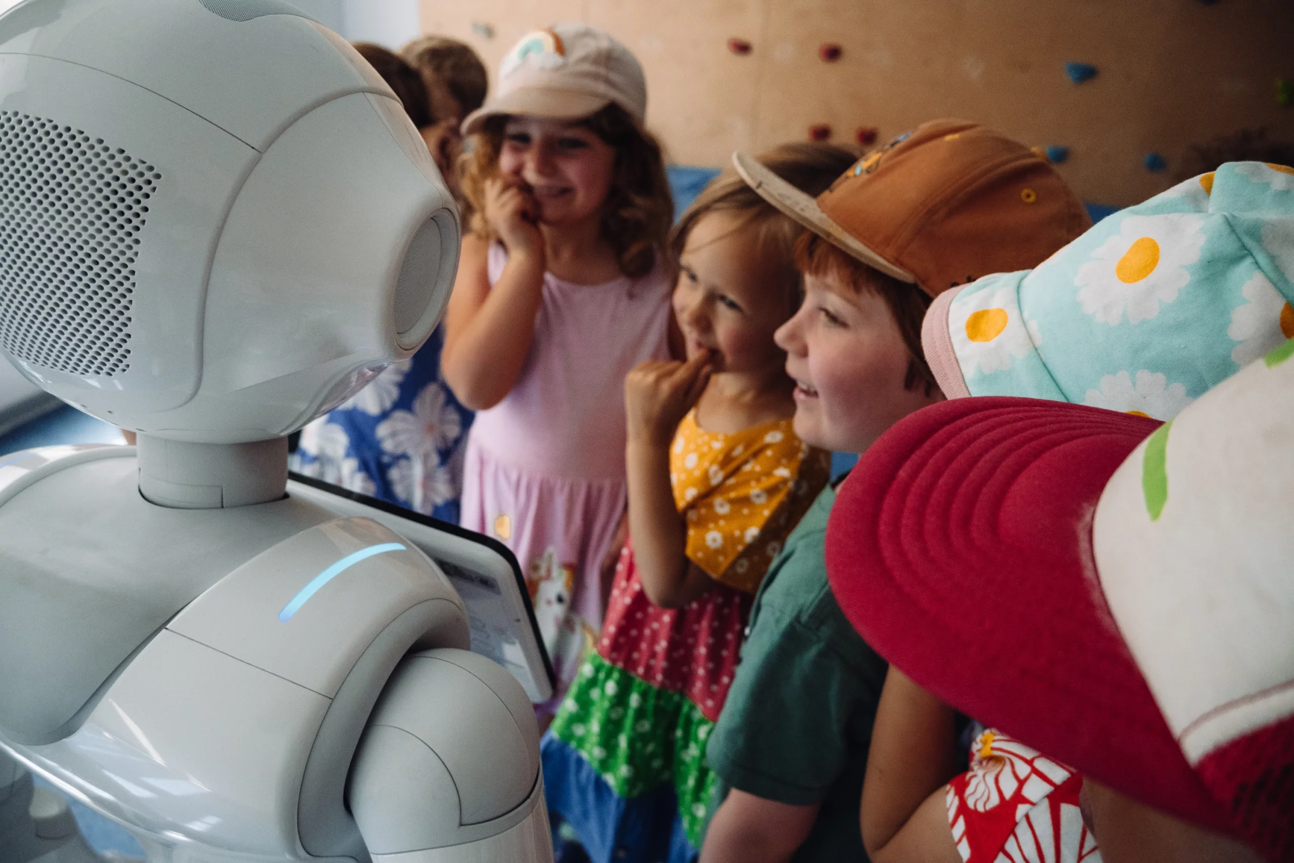 A group of kids interacts happily with the humanoid robot Pepper.